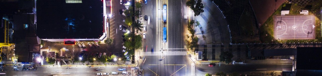 Gece yukarıdan görülen bir şehrin aydınlatılmış sokak kavşağı 