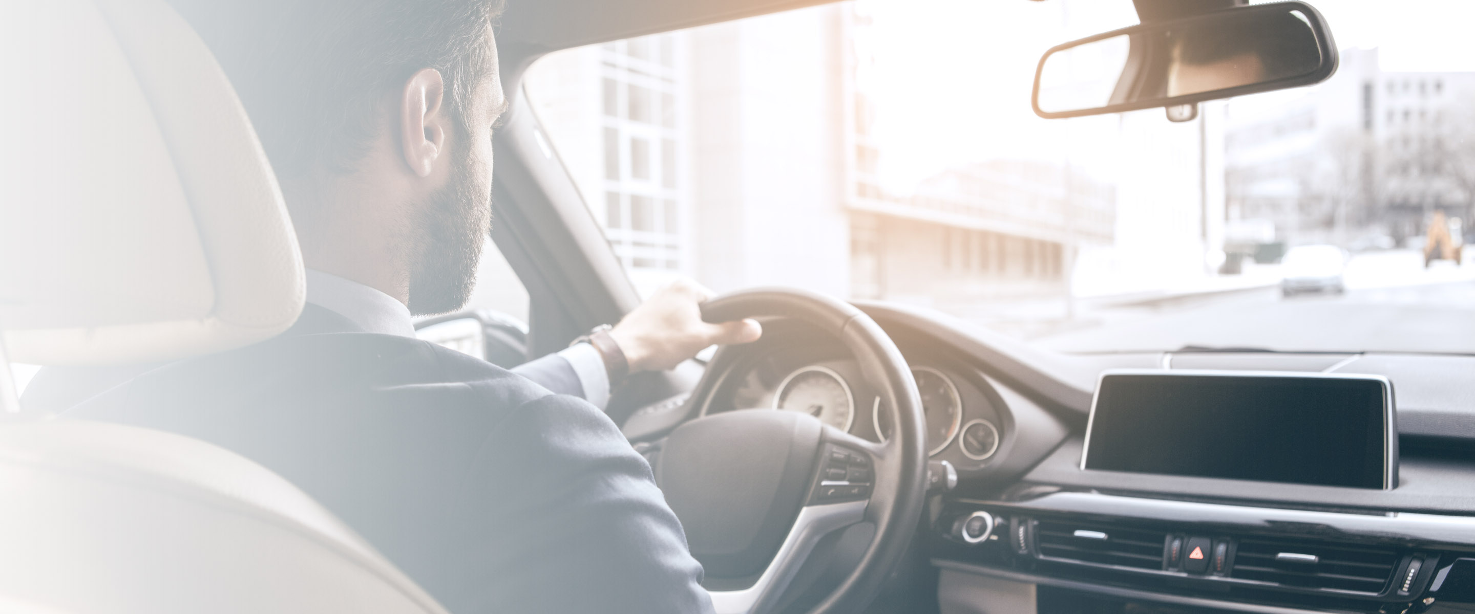 Uomo al volante che ricerca una stazione di ricarica elettrica